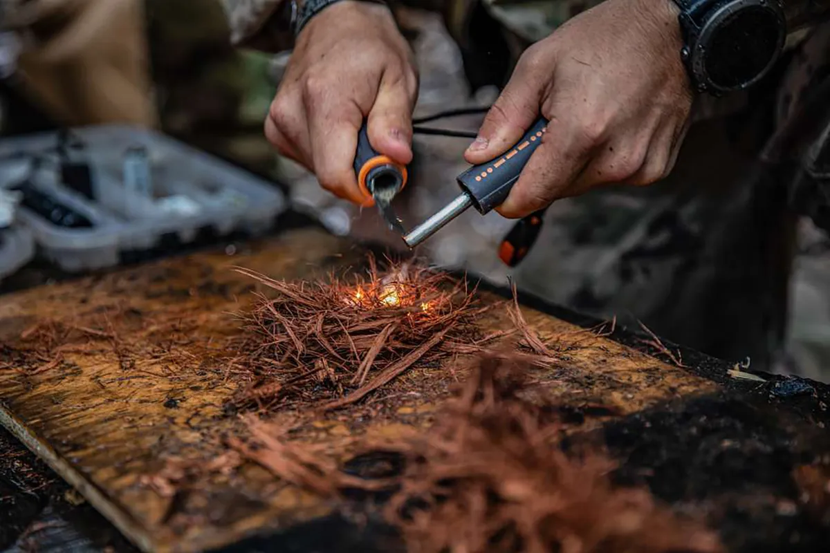 Vonken vliegen van firesteel op droog tondel tijdens het starten van vuur