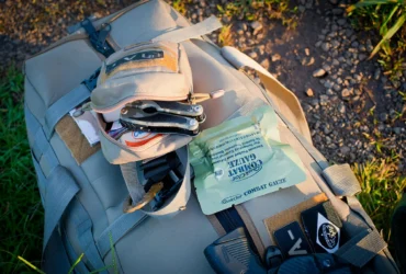 Overzicht van een survivalkit met water, EHBO, zaklamp, multitool en voedsel