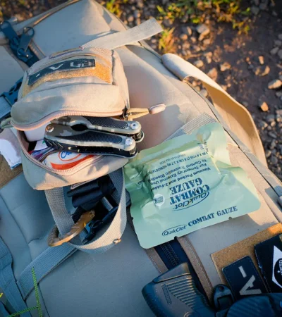 Overzicht van een survivalkit met water, EHBO, zaklamp, multitool en voedsel