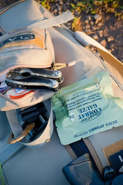 Overzicht van een survivalkit met water, EHBO, zaklamp, multitool en voedsel