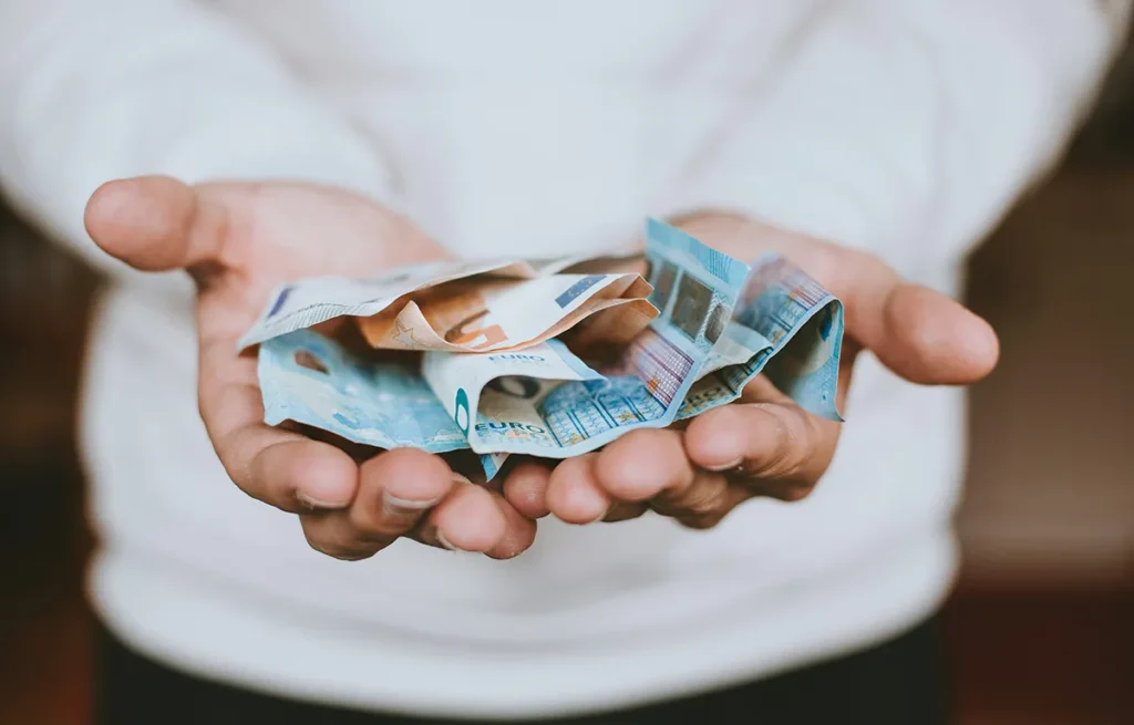 Persoon geeft contant geld aan bij een aankoop in noodsituatie