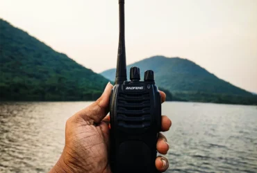 Man gebruikt een walkietalkie in buitengebied voor noodcommunicatie