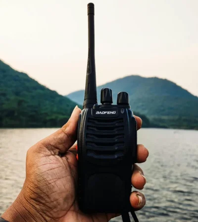 Man gebruikt een walkietalkie in buitengebied voor noodcommunicatie