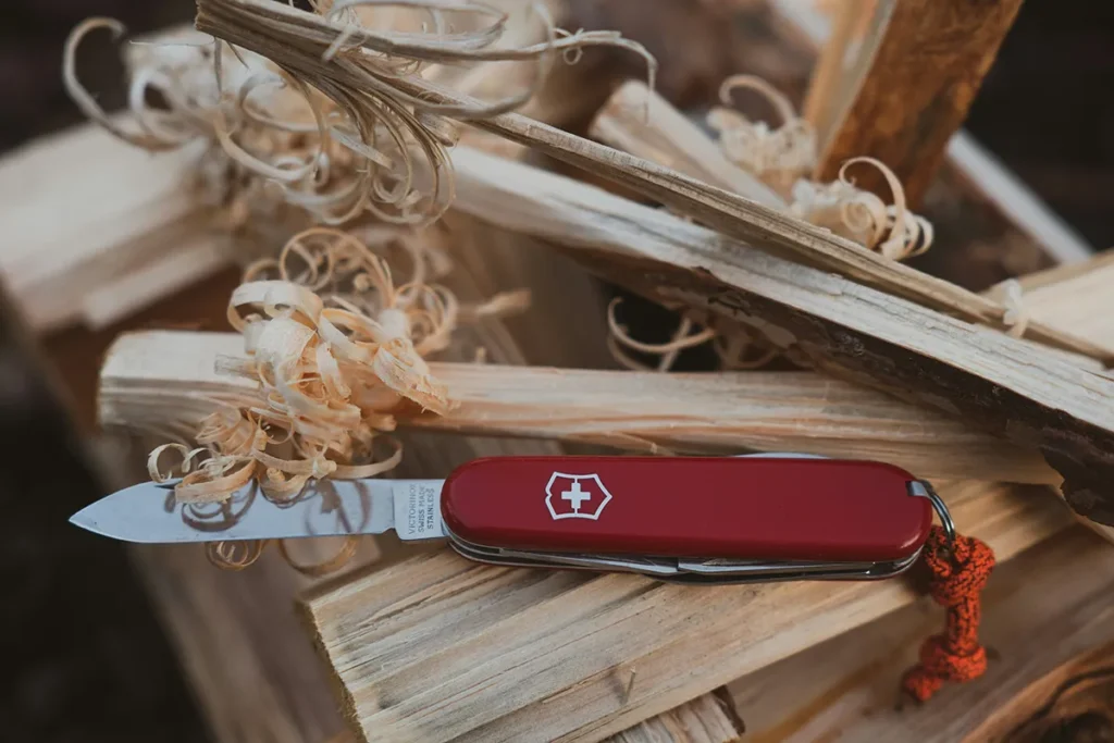 Survivalmes met rood handvat tijdens bushcraft in het bos