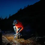 Persoon die water filtert met een draagbaar waterfilter in een noodsituatie in de buitenlucht