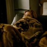 Persoon gewikkeld in een deken in een koude kamer zonder verwarming