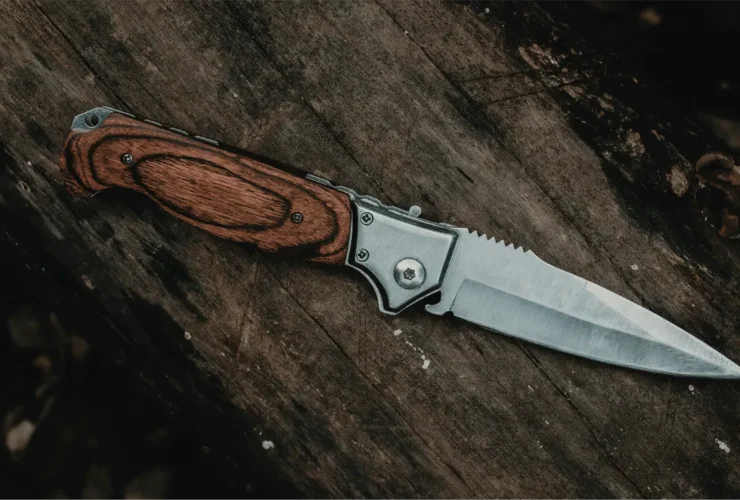 Survival mes liggend op hout in een bosomgeving