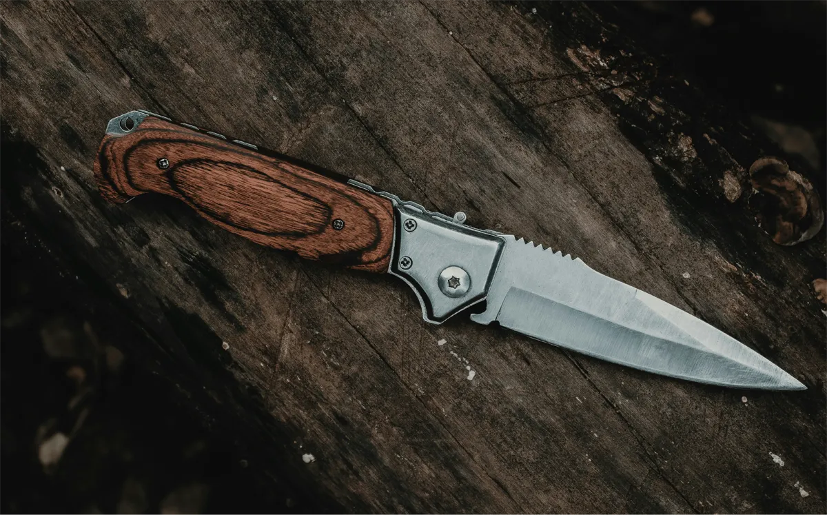 Survival mes liggend op hout in een bosomgeving