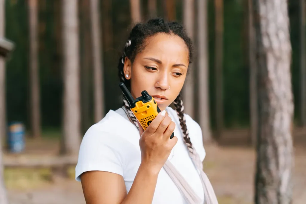 Vrouw buiten via een walkie talkie aan het praten