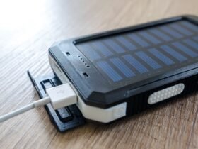 Powerbank met zonnepaneel en een aangesloten USB-kabel op een houten tafel