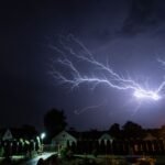 Bliksem boven een woonwijk in de nacht, het moment waarop een aggregaat noodstroom levert