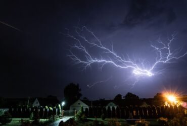 Bliksem boven een woonwijk in de nacht, het moment waarop een aggregaat noodstroom levert