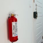 Rode brandblusser aan de muur in de gang van een woning