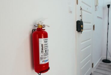 Rode brandblusser aan de muur in de gang van een woning