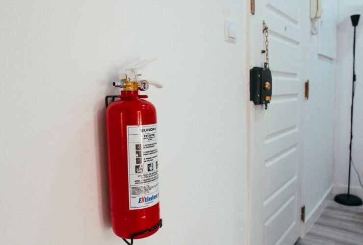 Rode brandblusser aan de muur in de gang van een woning