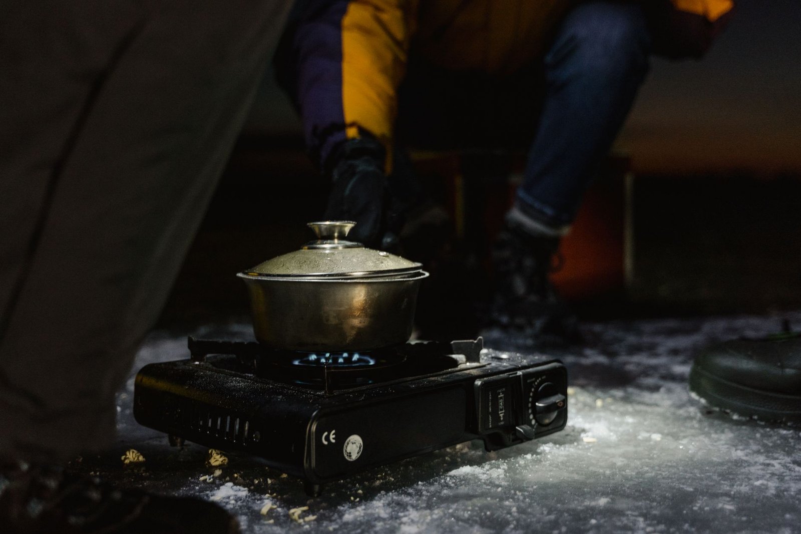 Pan met water op een draagbare gasbrander buiten in de sneeuw