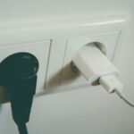 Twee stekkers in een stopcontact aan de muur