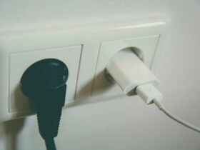 Twee stekkers in een stopcontact aan de muur