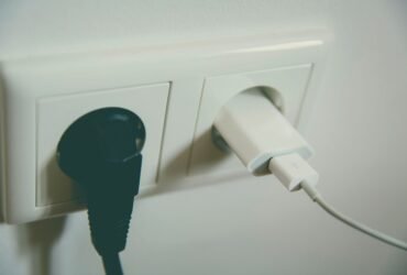 Twee stekkers in een stopcontact aan de muur