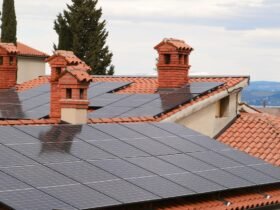 Daken met rode dakpannen en schoorstenen vol zonnepanelen