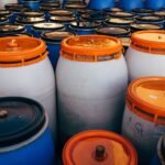 Blauwe en witte plastic vaten met oranje deksels
