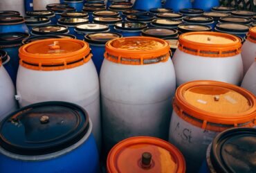 Blauwe en witte plastic vaten met oranje deksels