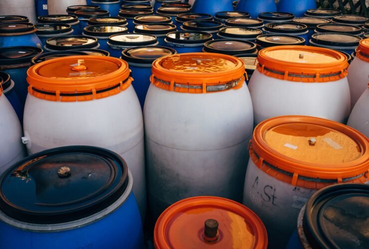 Blauwe en witte plastic vaten met oranje deksels
